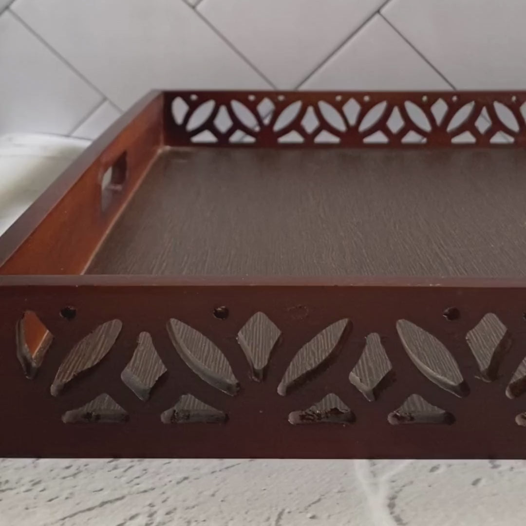 A beautiful Wooden Tray with lotus patterns on the side with an artificial lavender flower kept carelessly. A zoomed in Video.